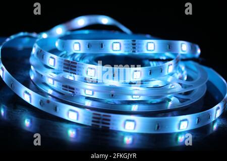 Gros plan d'une bande de silicone à LED avec lumières bleues sur fond noir Banque D'Images