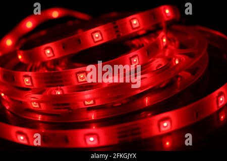 Gros plan d'une bande de silicone à LED avec lumières rouges sur fond noir Banque D'Images