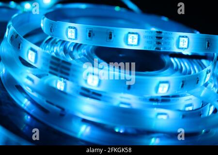 Gros plan d'une bande de silicone à LED avec lumières bleues sur fond noir Banque D'Images