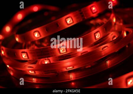 Gros plan d'une bande de silicone à LED avec lumières rouges sur fond noir Banque D'Images