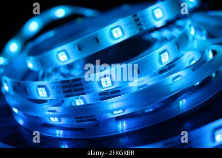 Gros plan d'une bande de silicone à LED avec lumières bleues sur fond noir Banque D'Images