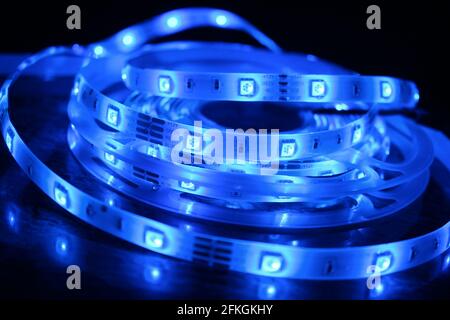 Gros plan d'une bande de silicone à LED avec lumières bleues sur fond noir Banque D'Images