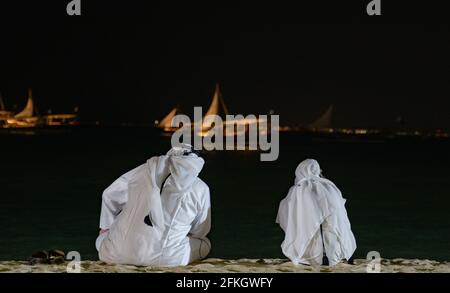 Deux hommes avec costume arabe à l'observation de dhows dans la mer. Banque D'Images