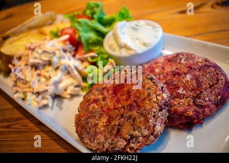 Hamburgers au quinoa et aux graines, avec pommes de terre rôties, salade fraîche et vinaigrette au fromage concombre et à la menthe (plats végétariens). Banque D'Images