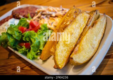 Hamburgers au quinoa et aux graines, avec pommes de terre rôties, salade fraîche et vinaigrette au fromage concombre et à la menthe (plats végétariens). Banque D'Images