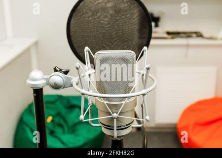 Microphone professionnel sur l'arrière-plan du mur lumineux. Microphone studio pour un enregistrement professionnel. Studio d'enregistrement sonore. Banque D'Images