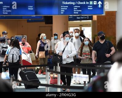 Orlando, États-Unis. 1er mai 2021. Les passagers portant un masque facial comme mesure préventive contre la propagation du covid-19 arrivent à l'aéroport international d'Orlando. Le 30 avril 2021, l'Administration de la sécurité des transports a prolongé le mandat du masque fédéral, qui devait expirer le 11 mai, jusqu'en septembre 13 pour tous les passagers aériens de plus de 2 ans. (Photo de Paul Hennessy/SOPA Images/Sipa USA) crédit: SIPA USA/Alay Live News Banque D'Images