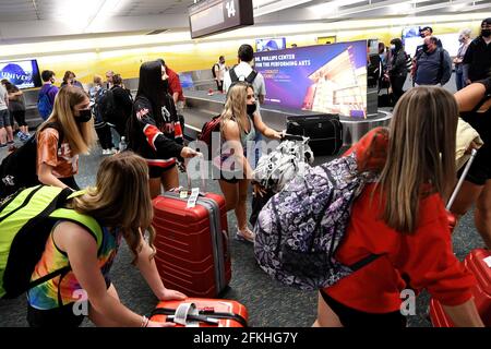 Orlando, États-Unis. 1er mai 2021. Les passagers portant un masque facial comme mesure préventive contre la propagation du covid-19 ramassent leurs bagages à l'aéroport international d'Orlando. Le 30 avril 2021, l'Administration de la sécurité des transports a prolongé le mandat du masque fédéral, qui devait expirer le 11 mai, jusqu'en septembre 13 pour tous les passagers aériens de plus de 2 ans. Crédit : SOPA Images Limited/Alamy Live News Banque D'Images