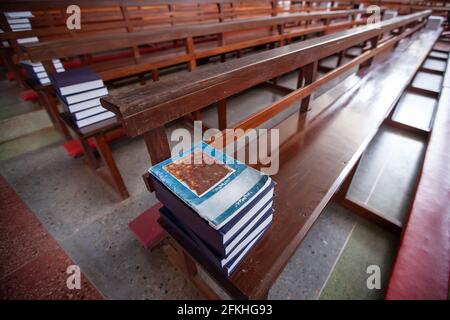 Livre de prière catholique thaï sur les rangées de bancs d'église en bois, lumière douce de beaming brille à l'intérieur d'une église. Ancienne église en Thaïlande. Banque D'Images