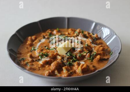 Chou-fleur rôti avec sauce tomate et noix de cajou. Un plat d'accompagnement populaire du nord de l'Inde, connu sous le nom de gobi Butter masala. Prise de vue sur fond blanc Banque D'Images
