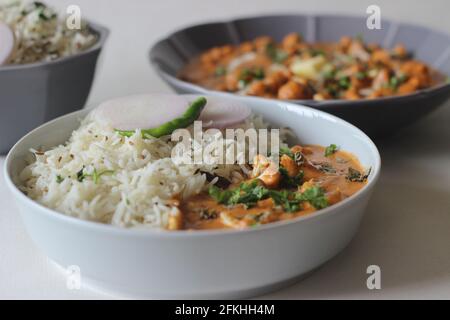 Riz basmati aromatisé au cumin servi avec chou-fleur rôti préparé avec une sauce tomate et noix de cajou.Combinaison de repas populaire du nord de l'Inde Banque D'Images