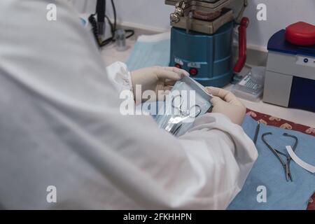 L'infirmière emballe un instrument dentaire avant sa stérilisation dans un clinique dentaire - concept de technologie moderne en médecine Banque D'Images