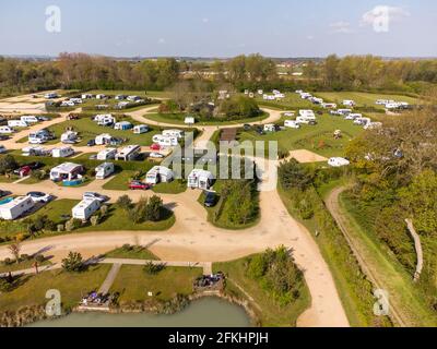 Henlow, Bedfordshire, Royaume-Uni. 2 mai 2021. Les règles actuelles signifient que seuls les vacanciers dans des unités autonomes peuvent passer la nuit sur des campings au Royaume-Uni, donc pendant que les sites sont occupés avec des caravanes et des propriétaires de camping-cars comme le montre cette vue aérienne, Les personnes qui campent habituellement dans des tentes devront attendre jusqu'au 17 mai quand toutes les installations de camping telles que les toilettes et les toilettes seront rouvertes. Les règles ont signifié qu'il y a eu une augmentation de la demande de camping-cars et de caravanes qui a entraîné la hausse des prix et créé une pénurie de stock pour certains concessionnaires. Banque D'Images