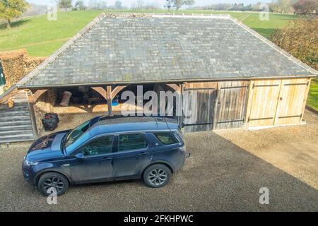 Vue latérale haute sur Land Rover Discovery dans la cour de la ferme Banque D'Images