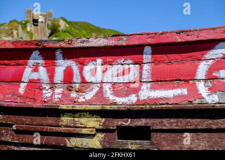 Idée de Staycation.gros plan d'un vieux bateau de pêche beached, avec Angel écrit sur lui au Stade, Hastings. East Hill Cliff Railway en arrière-plan. ROYAUME-UNI. Banque D'Images