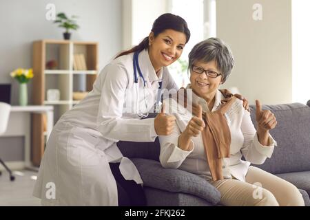 Femme hispanique médecin et vieille femme patient gestante pouces vers le haut vers l'appareil photo Banque D'Images