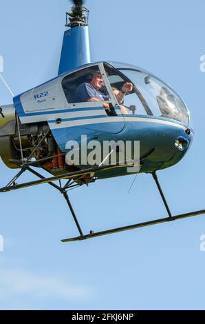 Robinson R22 Beta hélicoptère frontal, avec des pilotes dans le cockpit à bulles. Petit hélicoptère de base utilisé pour l'entraînement en vol Banque D'Images