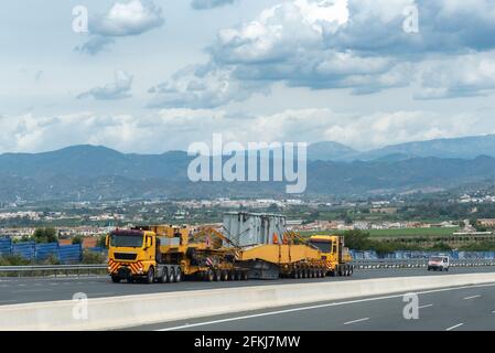 Transport spécial, deux camions, l'un devant et l'autre derrière, pour déplacer une grande et lourde pièce sur la route. Banque D'Images