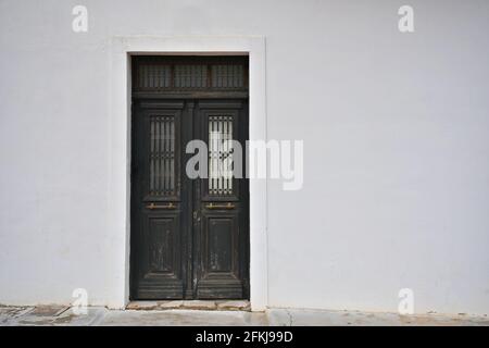 Maison rurale porte d'entrée en bois marron sur un mur blanchi à la chaux à Leonidio, Arcadia Péloponnèse, Grèce. Banque D'Images