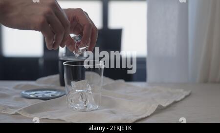 homme faisant du cola avec de la glace dans verre à verre sur table en chêne, photo large Banque D'Images