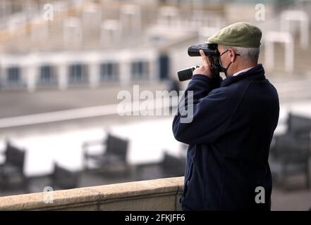 Un spectateur regarde l'action à travers des jumelles pendant la 1000 Guinéas Day, dans le cadre du festival de Guinéas QIPCO à l'hippodrome de Newmarket. Date de la photo: Dimanche 2 mai 2021. Banque D'Images