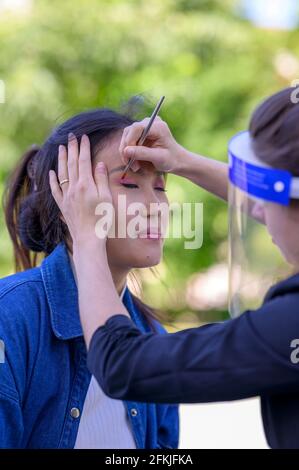 Une jolie mongole est composée dans un parc par un maquilleur pour une séance photo. Banque D'Images