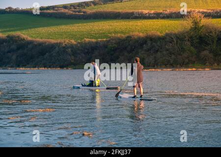 Une famille de vacanciers qui s'amusent à pagayer leurs paddleboards Stand Up à marée haute sur la rivière Gannel à Newquay en Cornouailles. Banque D'Images