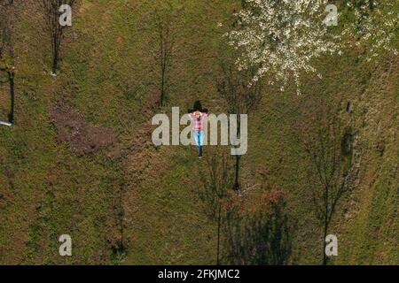 Agricultrice qui s'est posée dans un verger de cerisier biologique, une image de haut en bas de drone pov de femme agronome se reposant à l'extérieur Banque D'Images