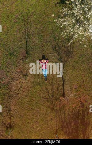 Agricultrice qui s'est posée dans un verger de cerisier biologique, une image de haut en bas de drone pov de femme agronome se reposant à l'extérieur Banque D'Images