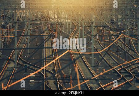 Infrastructure ferroviaire moderne avec plusieurs voies ferroviaires au coucher du soleil. Téléobjectif. Banque D'Images
