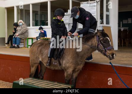 Garçon avec le syndrome de Down sur le cheval, équitation pour handicapés à Muirfield Riding Therapy, East Lothian, Écosse, Royaume-Uni Banque D'Images