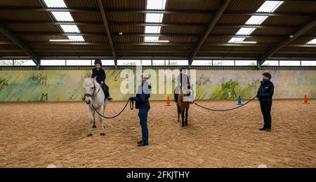 Des garçons sur des chevaux en séance thérapeutique dans l'arène d'équitation à Riding for Disabled, Muirfield Riding Therapy, East Lothian, Écosse, Royaume-Uni Banque D'Images