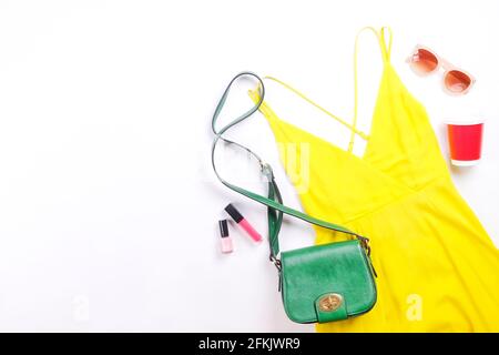 Soldes internationaux pour la journée des femmes. Vêtements et accessoires pour femme, collection printemps été. Robe jaune, chapeau de paille et sac à bandoulière, lunettes de soleil marron Banque D'Images