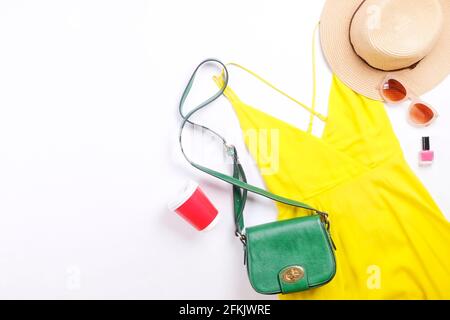 Soldes internationaux pour la journée des femmes. Vêtements et accessoires pour femme, collection printemps été. Robe jaune, chapeau de paille et sac à bandoulière, lunettes de soleil marron Banque D'Images