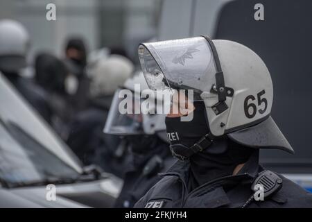 Hambourg, Allemagne - 1er mai 2021 : police anti-émeute sur le côté d'une manifestation avec casques pendant. Des manifestants en arrière-plan le jour de mai, fête du travail Banque D'Images