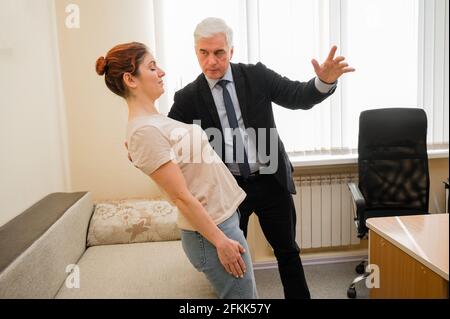 Homme mûr à cheveux gris hypnotises femme caucasienne pendant la séance d'hypnothérapie. Le psychologue utilise des traitements alternatifs pour l'esprit subconscient Banque D'Images