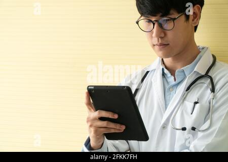 Jeunes médecins asiatiques utilisant des comprimés pour vérifier les données et les informations pour l'examen de santé des patients. Concept de numérique, de technologie et de communication Banque D'Images