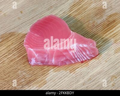 Filet de thon blanc frais et rose non emballé sur une planche à découper en bambou en bois Banque D'Images