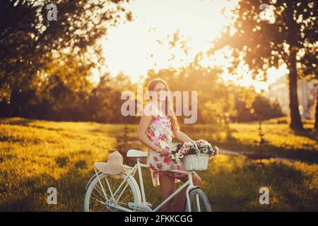 photo avec effet artistique. ton vintage. style rétro. film. jeune femme avec un vélo dans le parc Banque D'Images