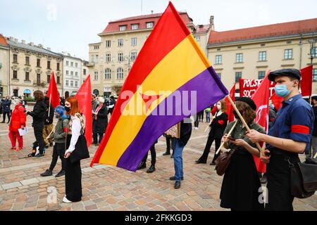 Cracovie, Pologne. 1er mai 2021. Un membre du Parti socialiste polonais est vu porter un drapeau du Front populaire espagnol pendant la manifestation.la Journée internationale des travailleurs, également connue sous le nom de Fête du travail ou de Mai, a une longue tradition en Pologne. Avant la chute du communisme, des événements de propagande avaient lieu ce jour-là, c’est maintenant un jour pour les jeunes adultes de gauche d’exprimer leurs réserves sur le marché du travail et le manque de justice sociale qu’il implique, En Pologne, forcer les travailleurs à travailler de manière autonome et les violations des droits du travail sont des pratiques courantes. Crédit : SOPA Images Limited/Alamy Live News Banque D'Images