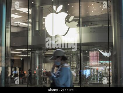 Pékin, Chine. 28 avril 2021. Les touristes marchent devant un magasin de pommes sur la rue Wangfujing à Beijing. Récemment, l'Union européenne a officiellement lancé un procès anti-monopole contre Apple. C'est la première fois que l'Union européenne intente un procès anti-monopole contre Apple, ce qui peut entraîner une amende de 10% de son chiffre d'affaires mondial. Le chiffre d'affaires d'Apple pour l'exercice 2020 s'élève à 274.515 milliards de dollars américains, soit 10 % ou 27.4 milliards de dollars américains, soit environ 177.3 milliards de yuans. Crédit : SOPA Images Limited/Alamy Live News Banque D'Images