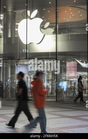 Pékin, Chine. 28 avril 2021. Les touristes marchent devant un magasin de pommes sur la rue Wangfujing à Beijing. Récemment, l'Union européenne a officiellement lancé un procès anti-monopole contre Apple. C'est la première fois que l'Union européenne intente un procès anti-monopole contre Apple, ce qui peut entraîner une amende de 10% de son chiffre d'affaires mondial. Le chiffre d'affaires d'Apple pour l'exercice 2020 s'élève à 274.515 milliards de dollars américains, soit 10 % ou 27.4 milliards de dollars américains, soit environ 177.3 milliards de yuans. Crédit : SOPA Images Limited/Alamy Live News Banque D'Images