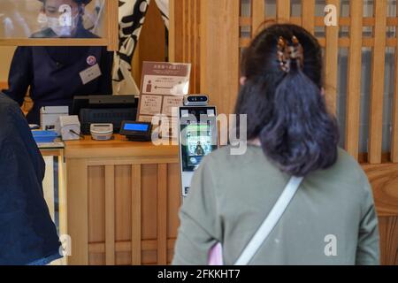 ISE, Japon. 1er mai 2021. Lors des fêtes de la semaine d'or, une cliente fait contrôler sa température corporelle à l'aide d'une machine installée dans un distributeur de thé près du sanctuaire ISE Jingu.les responsables des préfectures du Japon ont exhorté les résidents à éviter tout déplacement inutile, le pays étant confronté à une quatrième vague de pandémie de coronavirus avec moins de trois Plusieurs mois avant les Jeux Olympiques de Tokyo. Crédit : SOPA Images Limited/Alamy Live News Banque D'Images