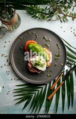 Sandwich à l'avocat avec rôti de bœuf et œuf poché Banque D'Images