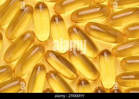 Softgels Omega 3 ou capsules d'huile de poisson, fond jaune de pilules. Banque D'Images