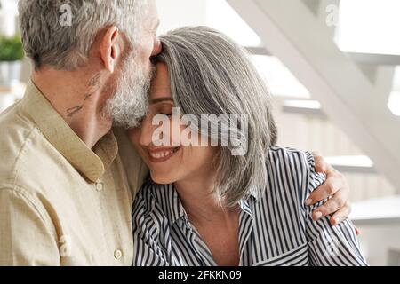 Heureux affectueux mûr mari embrassant femme embrassant appréciant la tendresse. Banque D'Images