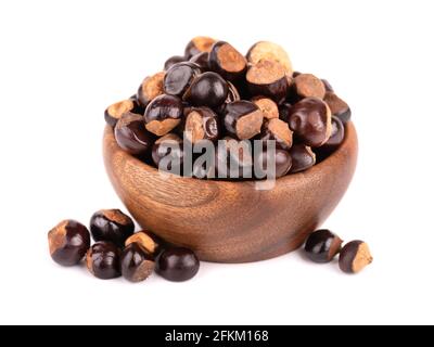 Graines de guarana dans un bol en bois, isolées sur fond blanc. Supplément alimentaire guarana, source de caféine pour boissons énergétiques. Banque D'Images