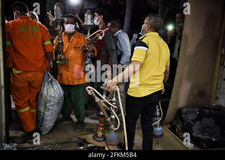 Le Caire, Égypte. 02 mai 2021. Les travailleurs du gouvernorat du Caire participent à une campagne d'inspection des restaurants et cafés qui violent les mesures de précaution du coronavirus dans le district d'El Nozha. Les autorités municipales égyptiennes ont décidé de fermer les parcs publics et les plages avant la célébration de Sam El-Nessim, le pays ayant été témoin d'une augmentation des cas de coronavirus. Credit: Sayed Hassan/dpa/Alay Live News Banque D'Images