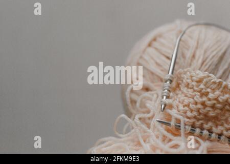 Balle de fil de chair pour aiguilles de tricotage et de tricotage, fond gris. Banque D'Images