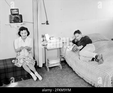 Mme Shimizu assis sur la table avec des laçure, M. Shimizu lisant sur le lit, Manzanar Relocation Center, Californie, Etats-Unis, Ansel Adams, Collection du Centre de réinstallation de la guerre de Manzanar, 1943 Banque D'Images